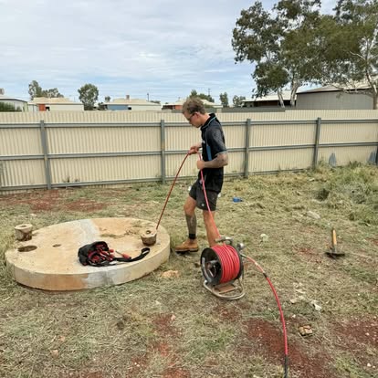 Apprentice running a high-pressure jetter hose at a Kalgoorlie residential job