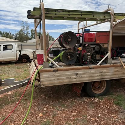 High-pressure water jetter rig mounted on a flatbed truck