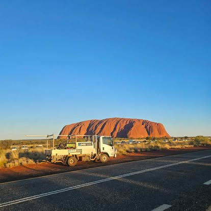 D&R service truck parked on the highway with Uluru in the background